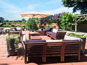 a patio with several benches and an umbrella at Blashford Manor Farm House in Ellingham