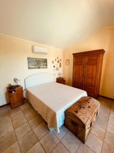 a bedroom with a bed and a wooden cabinet at Villa con piscina sul lago in San Feliciano