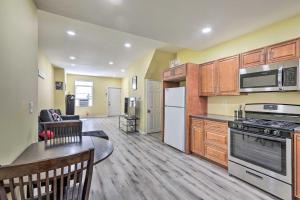 a kitchen with wooden cabinets and appliances and a living room at Philly Townhome with Gas Grill about 5 Mi to Dtwn! in Philadelphia