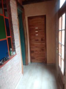 une chambre vide avec une porte et des fenêtres en bois dans l'établissement Chañares, à San Javier