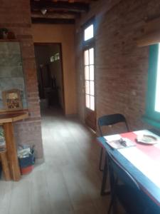 una stanza con tavolo, sedie e un muro di mattoni di Chañares a San Javier