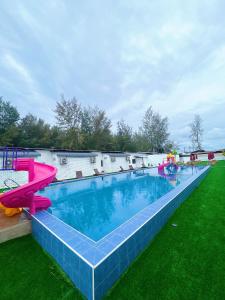 a large swimming pool with a water slide at D’Razna Inn in Kuala Terengganu