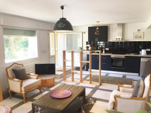 a living room with a table and a kitchen at Getxo Garden Houses - The Chalet in Getxo
