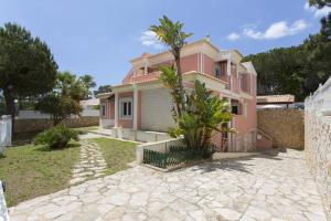 a pink house with a fence in front of it at Villa Falesia Mar by Villa Plus in Olhos de Água