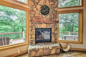 a stone fireplace in a living room with windows at Luxe Wintergreen Resort Escape with Hot Tub! in Roseland