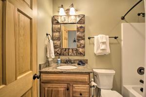 un bagno con lavandino, WC e specchio di Luxe Wintergreen Resort Escape with Hot Tub! a Roseland Altre 32 foto