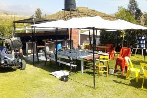 einen Tisch mit einem Regenschirm im Gras und Stühlen in der Unterkunft Casa de Campo Arequipa - Disfruta de la naturaleza in Arequipa