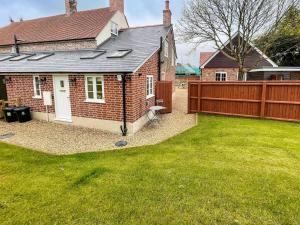 a brick house with a fence and a yard at The Old Pump House - Uk34451 in Child Okeford