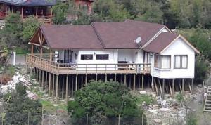 une maison au-dessus d'une maison sur des potes dans l'établissement Los Quenes River Lodge, à Los Queñes