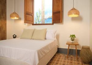 a bedroom with a bed with a window and a table at Casa Rosa - Alma Hotels in Santa Marta