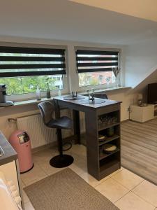 uma cozinha com uma ilha com um lavatório e duas janelas em Ferienwohnung OG Zentrum Neuss em Neuss