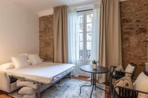 a bedroom with a bed and a table and a window at Habitaciones Apartamento B&B Plaza Nueva 8 in Bilbao