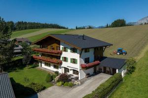 eine Luftansicht eines Hauses mit Traktor auf einem Feld in der Unterkunft Gästehaus Bramböck in Bad Häring