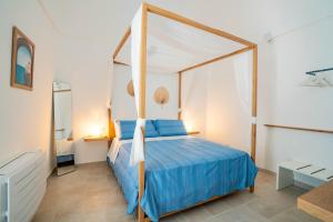 a bedroom with a blue bed with a canopy at Marianna 25 in Polignano a Mare