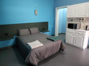 a bedroom with a large bed with a microwave at Hasate Guest House ,4 st james street Oakdale Belliville Cape Town South Africa in Cape Town