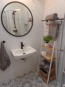 La salle de bains est pourvue d'un lavabo et d'un miroir. dans l'établissement Lucky Summer Marsalforn Holiday Apartment, à Marsalforn