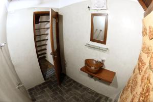 La salle de bains est pourvue d'un lavabo et d'un miroir mural. dans l'établissement Sky View Cabin Unawatuna, à Unawatuna