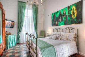 a bedroom with a bed with green curtains and a chandelier at Romance al Colosseo in Rome