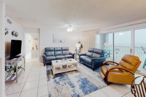 a living room with couches and a tv and a table at Long Beach Resort #T2-304 in Panama City Beach