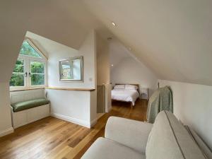 a attic living room with a couch and a bed at Candlewick Cottage in Steeple Aston