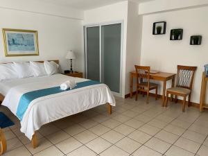 um quarto com uma cama, uma mesa e cadeiras em Apartamentos Reforma em Guatemala