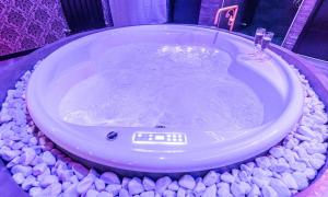 a bath tub with rocks around it in a bathroom at Cupidon Love Room in Vesoul