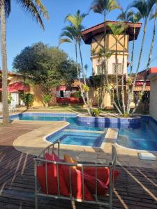 um resort com piscina e palmeiras em Hotel Beira Rio Guararema em Guararema