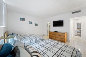 a bedroom with a bed and a tv on a wall at Oceanfront Luxury Condo - Private Beach Access, Pool & Game Room! in Hollywood +35 photos