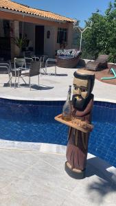 a statue of a head with a vase on a table near a pool at Pousada Villa São Francisco in Boituva