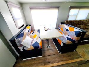 a small room with two chairs and a table at Wildwood Camper De Sleeps 6-7, in Dover