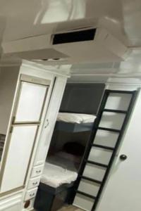 a room with a ladder leading to a bunk bed at Wildwood Camper De Sleeps 6-7, in Dover