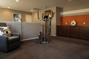 a room with a gym with a couch and exercise equipment at Cheerful 4 Bedroom Entire House Lots Of Open Space 