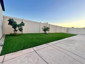 a backyard with a fence and a green lawn at Cheerful 4 Bedroom Entire House Lots Of Open Space 