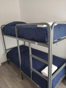 2 łóżka piętrowe w pokoju ze stołem w obiekcie La LLana Nova w mieście Ribes de Freser