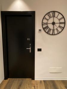 a black door with a clock on the wall at IL TIGLIO VERDE in Foggia