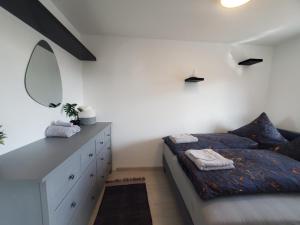 a bedroom with a bed and a dresser and a mirror at Luxus Apartment über den Dächern vom Allgäu in Sonthofen