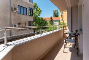 a balcony with a chair and a table on a building at Designed Apartment in Central Sofia in Sofia