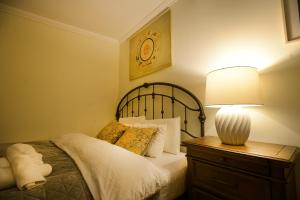 ein Schlafzimmer mit einem Bett mit einer Lampe auf einer Kommode in der Unterkunft The Zodiac Garden Hotel in Mzcheta