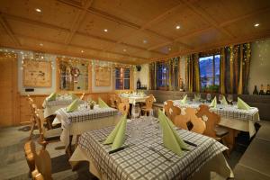 a restaurant with tables and chairs in a room at Hotel San Giovanni in Livigno