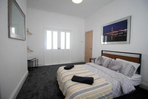 a bedroom with a bed with two black towels on it at Tower View House - 4 Bedroom - Newly Refurbished - 2 Mins walk to Beach in Blackpool