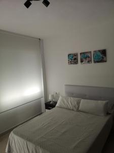 a bedroom with a white bed and a window at Apartamento 60 m2 en la playa in Torre de Benagalbón