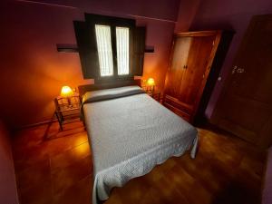 埃爾瓦斯的住宿－La Estrella de David, Apartamentos Rurales，一间卧室配有一张带窗户和两盏灯的床。