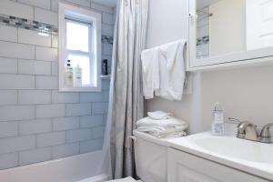 阿林頓的住宿－2 bd 1 bth near DC! 7081，白色的浴室设有水槽、浴缸和窗户。
