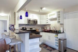 a kitchen with white cabinets and a counter with stools at 2 bd 1 bth near DC! 7081 in Arlington