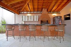 a patio with a bar with chairs and a fireplace at Business Park Hotel in Hortolândia