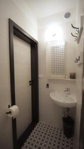 a bathroom with a white sink and a white door at SOMIMARE in Międzywodzie