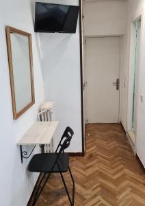 um quarto com uma mesa, uma cadeira e uma porta em Hostal Santa Barbara em Madri