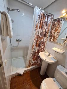 y baño con ducha y lavamanos. en Hostal Santa Barbara, en Madrid