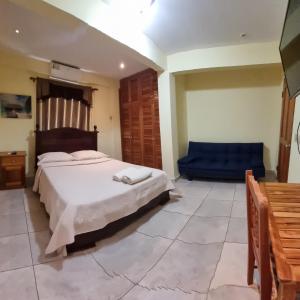 sypialnia z łóżkiem i niebieską kanapą w obiekcie Hostal Bocas Tropical Paradise w mieście Bocas del Toro