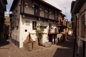 埃爾瓦斯的住宿－La Estrella de David, Apartamentos Rurales，阳台上的小巷,有鲜花建筑